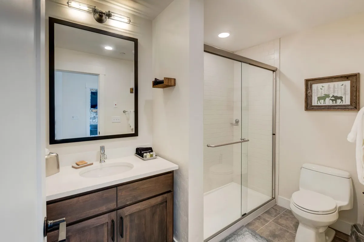 A modern, inviting bathroom featuring a sleek sink with contemporary fixtures, a glass-enclosed shower, and a stylish mirror, evoking freshness and relaxation.