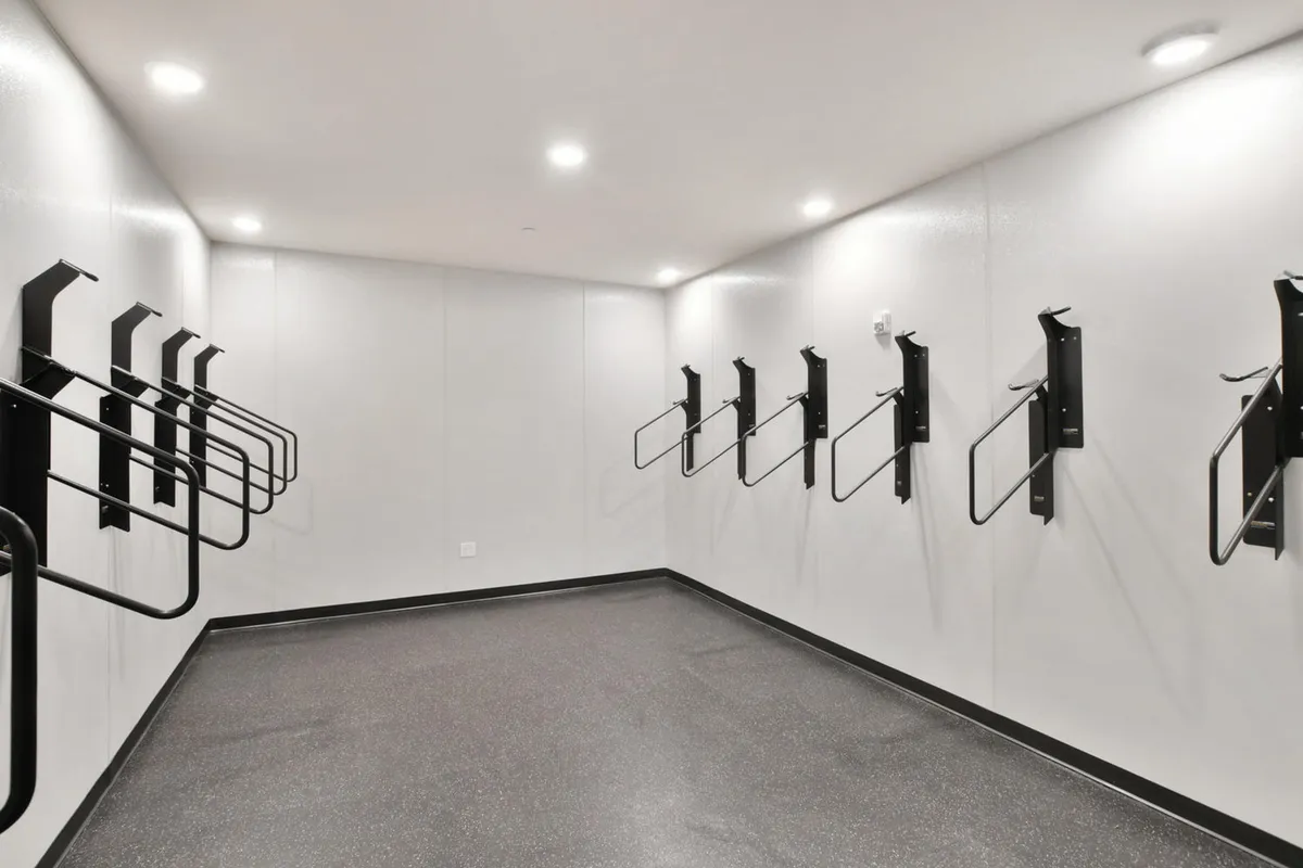 This interior shot features organized bike racks set against smooth walls and flooring, emphasizing a functional and community-oriented storage space. The environment appears clean, modern, and ready for active residents to store or retrieve their gear before and after outings.